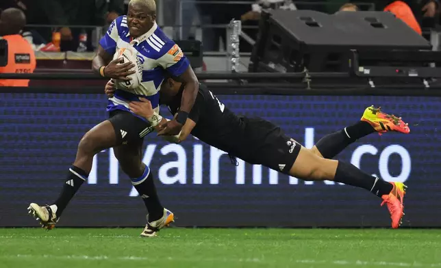 Stormers' Hacjivah Dayimani, left, is tackled by All Blacks' Caleb Clarke during a friendly rugby match between Stormers and All Blacks, in Cape Town, South Africa, Friday, Aug. 7, 2026. (AP Photo/Halden Krog)