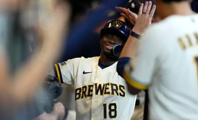 Milwaukee Brewers' Luis Lara is congratulated in the dugout after hitting a three-run home run for his first career home run during the eighth inning of a baseball game against the Seattle Mariners, Tuesday, Aug. 18, 2026, in Milwaukee. (AP Photo/Aaron Gash)