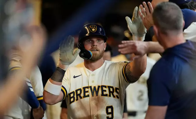 Milwaukee Brewers' Jake Bauers is congratulated in the dugout after hitting a two-run home run during the sixth inning of a baseball game against the Seattle Mariners, Tuesday, Aug. 18, 2026, in Milwaukee. (AP Photo/Aaron Gash)