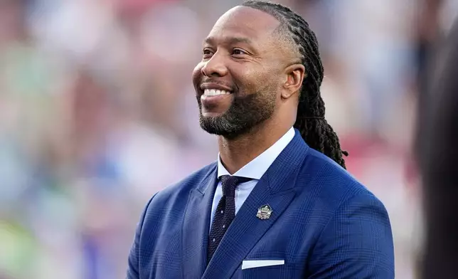 FILE - Former NFL player Larry Fitzgerald stands on the field for a tribute during the first half of the NFL Super Bowl 60 football game between the New England Patriots and the Seattle Seahawks, Feb. 8, 2026, in Santa Clara, Calif. (AP Photo/Julio Cortez, File)