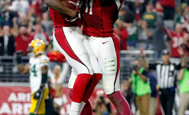 FILE - Arizona Cardinals wide receiver John Brown (12) celebrates his touchdown with teammate Larry Fitzgerald during the first half of an NFL football game against the Green Bay Packers, Dec. 27, 2015, in Glendale, Ariz. (AP Photo/Ross D. Franklin, File)