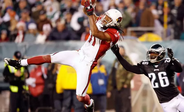 FILE - Arizona Cardinals wide receiver Larry Fitzgerald catches a pass in front of Philadelphia Eagles cornerback Lito Sheppard in the fourth quarter of an NFL football game in Philadelphia, Nov. 27, 2008. (AP Photo/Tom Mihalek, File)