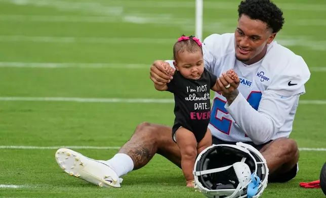Tennessee Titans cornerback Alontae Taylor spends time with his daughter Armani after practice during the NFL football team's training camp Saturday, Aug. 1, 2026, in Nashville, Tenn. (AP Photo/George Walker IV)