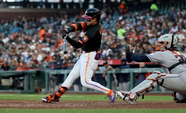 San Francisco Giants' Drew Gilbert, left, hits an RBI single in front of Houston Astros catcher Yainer Diaz, right, during the second inning of a baseball game in San Francisco, Tuesday, Aug. 11, 2026. (AP Photo/Jed Jacobsohn)