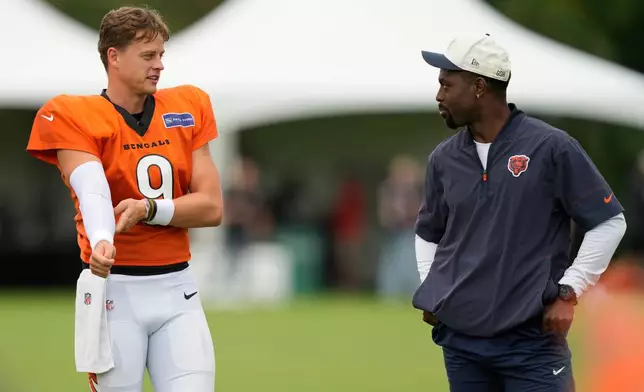 Chicago Bears quarterbacks coach J.T. Barrett, right, and and Cincinnati Bengals quarterback Joe Burrow, left, during a joint NFL football practice Thursday, Aug. 20, 2026, in Cincinnati. (AP Photo/Carolyn Kaster)
