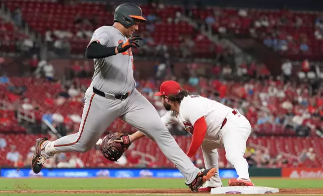 Baltimore Orioles' Samuel Basallo, left, singles as St. Louis Cardinals first baseman Alec Burleson handles the throw during the fourth inning of a baseball game Wednesday, Aug. 26, 2026, in St. Louis. (AP Photo/Jeff Roberson)