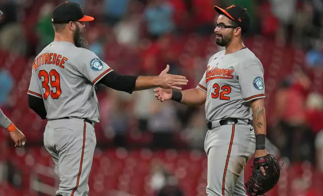 Baltimore Orioles' Christian Encarnacion-Strand (32) and Andrew Kittredge (39) celebrate a victory over the St. Louis Cardinals following a baseball game Wednesday, Aug. 26, 2026, in St. Louis. (AP Photo/Jeff Roberson)