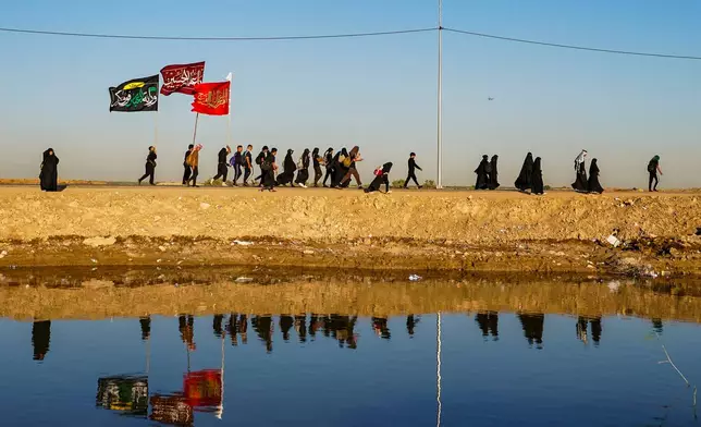 Shiite pilgrims march to Karbala, to observe Arbaeen that marks the end of a 40-day mourning period following the Day of Ashura, in Najaf, Iraq, Tuesday, July 28, 2026. (AP Photo/Anmar Khalil)