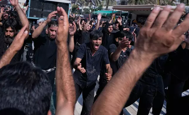 Shiite Muslim worshippers beat their chests in a ritual act of mourning as they march toward the Imam Hussein Shrine ahead of Arbaeen, the annual Shiite commemoration marking 40 days after Ashoura, in Karbala, Iraq, Monday, Aug. 3, 2026. (AP Photo/Hadi Mizban)
