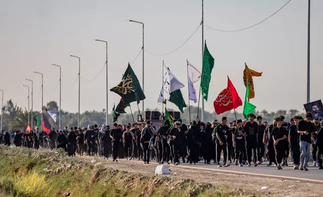 Shiite pilgrims march to Karbala, to observe Arbaeen that marks the end of a 40-day mourning period following the Day of Ashura, in Najaf, Iraq, Tuesday, July 28, 2026. (AP Photo/Anmar Khalil)