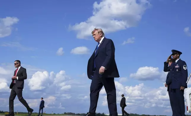 President Donald Trump, center, walks from Air Force One at Morristown Municipal Airport in Morristown, N.J., Friday, July 31, 2026, from Camp David, the presidential retreat. (AP Photo/Jacquelyn Martin)