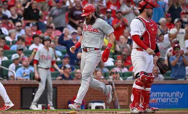 Philadelphia Phillies' Brandon Marsh, center, crosses home plate to score behind St. Louis Cardinals catcher Jimmy Crooks, right, in the second inning of a baseball game, Monday, Aug. 10, 2026, in St. Louis. (AP Photo/Joe Puetz)