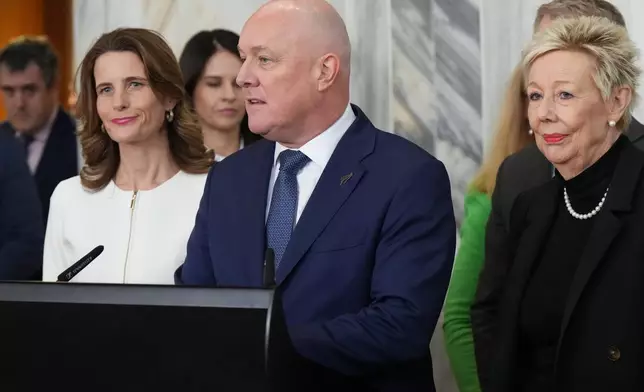 New Zealand Prime Minister Christopher Luxon, center, speaks to reporters at Parliament in Wellington, New Zealand, on Wednesday, Aug. 12 2026, after a leadership vote among his own party’s lawmakers. (AP Photo/Charlotte Graham-McLay)