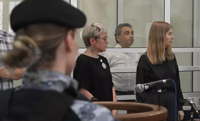 Lev Shlosberg, second right, senior member of the Yabloko party, stands in the defendant's box as the judge delivers a verdict in the case against him in a court in Pskov, Russia, Monday, Aug. 17, 2026. (AP Photo)
