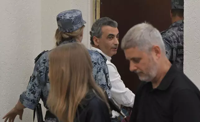 Lev Shlosberg, center, senior member of the Yabloko party, is being led out of the court room after a judge convicted him and sentenced him to more than 11 years in prison, in a court in Pskov, Russia, Monday, Aug. 17, 2026. (AP Photo)