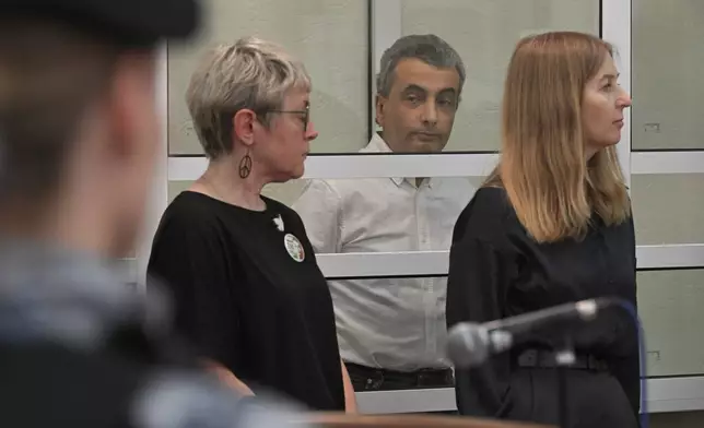 Lev Shlosberg, second right, senior member of the Yabloko party, stands in the defendant's box as the judge delivers a verdict in the case against him in a court in Pskov, Russia, Monday, Aug. 17, 2026. (AP Photo)