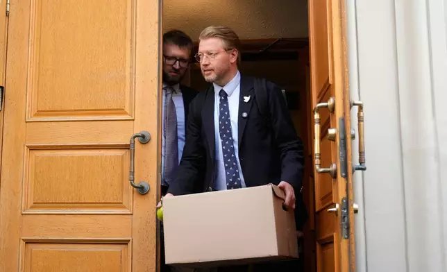 Yabloko party leader Nikolai Rybakov carries a box with documents leaving the Russia's Supreme Court after hearing an appeal on a lawsuit to bar the party from the upcoming parliamentary elections, in Moscow, Monday, Aug. 17, 2026. (AP Photo/Pavel Bednyakov)