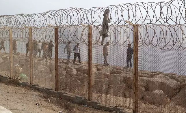 People who attempted crossing to the Spanish enclave of Ceuta return to the Moroccan northern town of Fnideq, Saturday, Aug. 1, 2026. (AP Photo)