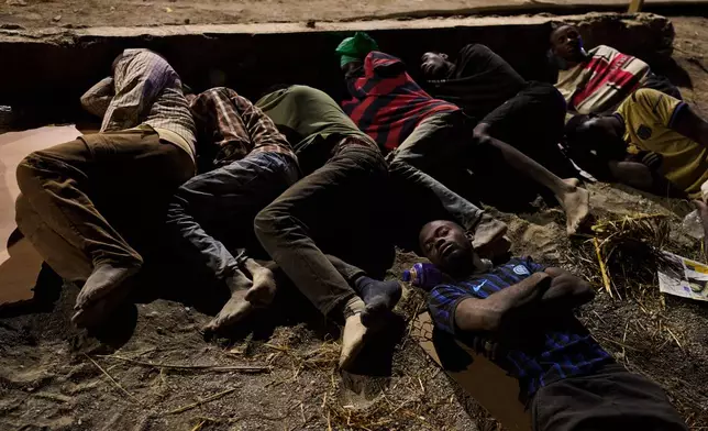 Migrants who crossed into Spain from Morocco sleep on a beach in the Spanish enclave of Ceuta, Monday, Aug. 3, 2026. (AP Photo/Bernat Armangue)