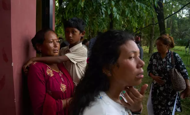 People wait for news of their relatives who are missing after flash flooding along the Trishuli River in Nepal's Nuwakot district, Wednesday, Aug. 26, 2026. (AP Photo/Niranjan Shrestha)