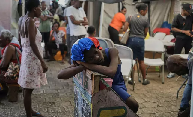 A girl rests at a shelter for families displaced by gang violence in Port-au-Prince, Haiti, Wednesday, Aug. 12, 2026. (AP Photo/Odelyn Joseph)