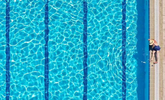 An aerial view of a woman sunbathing at the Dobrinja public pool in Sarajevo, Bosnia, Thursday, Aug. 6, 2026. (AP Photo/Armin Durgut)