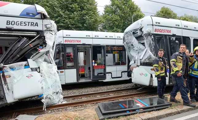 Emergency responders work at the scene of an accident where two trams collided in Gelsenkirchen, Germany, Thursday, Aug. 6, 2026. (AP Photo/Martin Meissner)