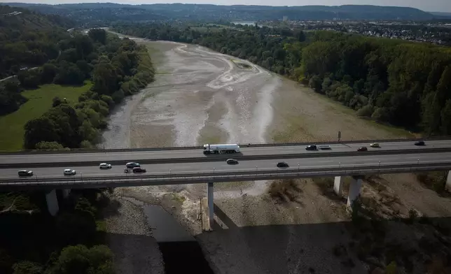 Vehicles cross the Rhine bridge on the A48 highway with a view of the low water levels on the Rhine, near Bendorf, Germany, Sunday, Aug. 9, 2026, (Thomas Frey/dpa via AP)