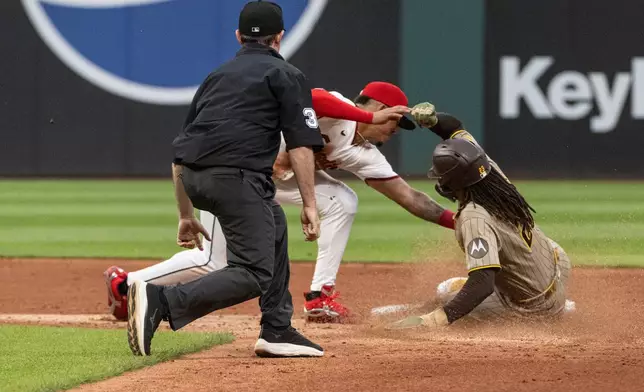 Cleveland Guardians' Angel Genao tags San Diego Padres' Fernando Tatis Jr. out on a sweat attempt as umpire Tyler Jones watches the play, during the third inning of a baseball game, Saturday, Aug. 15, 2026, in Cleveland. (AP Photo/Phil Long)