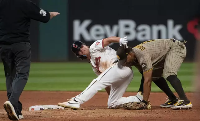 Cleveland Guardians' Petey Halpin, center, is safe at second base with a steal as San Diego Padres' Xander Bogaerts is late with the tag and umpire Tyler Jones calls the play during the fifth inning of a baseball game, Saturday, Aug. 15, 2026, in Cleveland. (AP Photo/Phil Long)