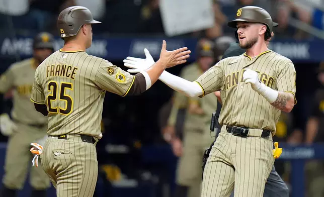 San Diego Padres' Jackson Merrill celebrates his two-run home run off Tampa Bay Rays pitcher Shane McClanahan with Ty France (25) during the sixth inning of a baseball game Friday, Aug. 28, 2026, in St. Petersburg, Fla. (AP Photo/Chris O'Meara)