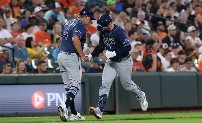 Tampa Bay Rays' Liam Hicks, right, is greeted by third base coach Brady Williams (4) as he runs the bases after hitting a home run off Baltimore Orioles pitcher Brandon Young during the second inning of baseball game in Baltimore, Saturday, Aug. 22, 2026. (AP Photo/Terrance Williams)