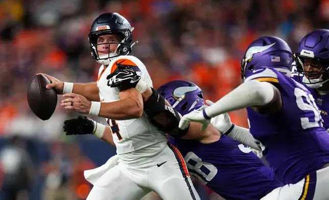 Denver Broncos quarterback Sam Ehlinger (4) throws a pass as he is hit by Minnesota Vikings linebacker Bo Richter (98) during the first half of a preseason NFL football game, Friday, Aug. 28, 2026, in Denver. (AP Photo/Jack Dempsey)