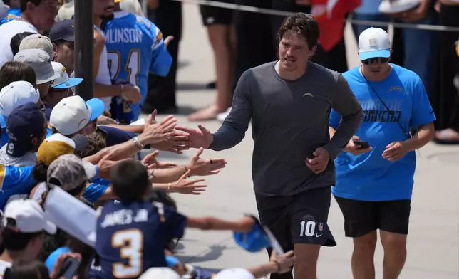 Los Angeles Chargers quarterback Justin Herbert greets fans during an NFL football training camp Tuesday, Aug. 4, 2026, in San Diego. (AP Photo/Gregory Bull)