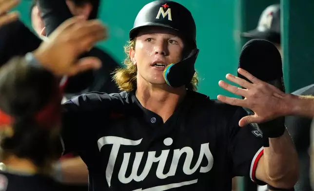 Minnesota Twins' Luke Keaschall celebrates in the dugout after scoring on single by Josh Bell during the eighth inning of a baseball game against the Kansas City Royals, Thursday, Aug. 6, 2026, in Kansas City, Mo. (AP Photo/Charlie Riedel)