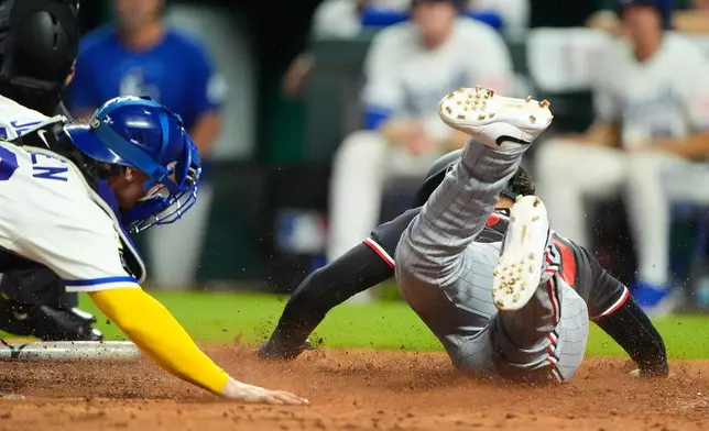 Minnesota Twins' Alex Jackson, right, beats the tag by Kansas City Royals catcher Carter Jensen, left, to score on a two-run single by Brooks Lee during the eighth inning of a baseball game, Thursday, Aug. 6, 2026, in Kansas City, Mo. (AP Photo/Charlie Riedel)