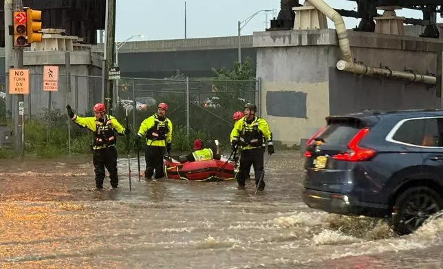 In this photo provided by the City of Jersey City, first responders try to rescue stranded people in Jersey City, N.J., Thursday, Aug. 20, 2026, after storms went through the area. (City of Jersey City via AP)null
