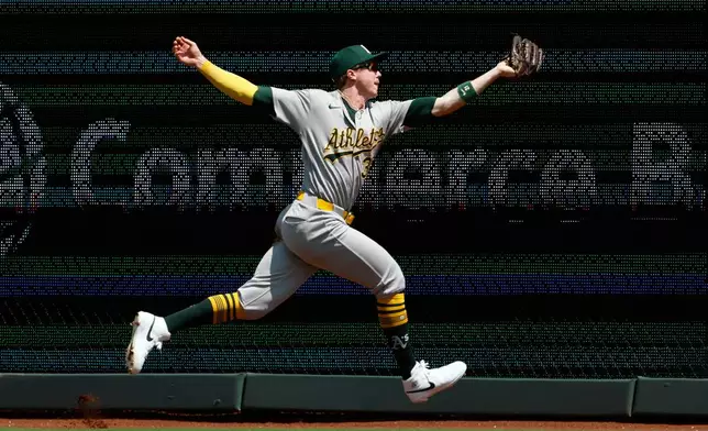 Athletics left fielder Zack Gelof reaches to catch a fly ball hit by Kansas City Royals' Nick Loftin during the first inning of a baseball game in Kansas City, Mo., Thursday, Aug. 20, 2026. (AP Photo/Colin E. Braley)