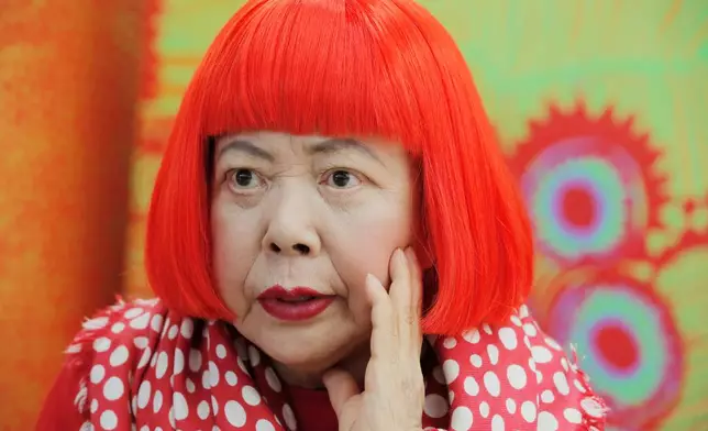 FILE - Japanese avant-garde artist Yayoi Kusama, wearing a bright red wig and a Louis Vuitton polka dot scarf, speaks during an interview at her studio in Tokyo, on Aug. 1, 2012. (AP Photo/Itsuo Inouye, File)
