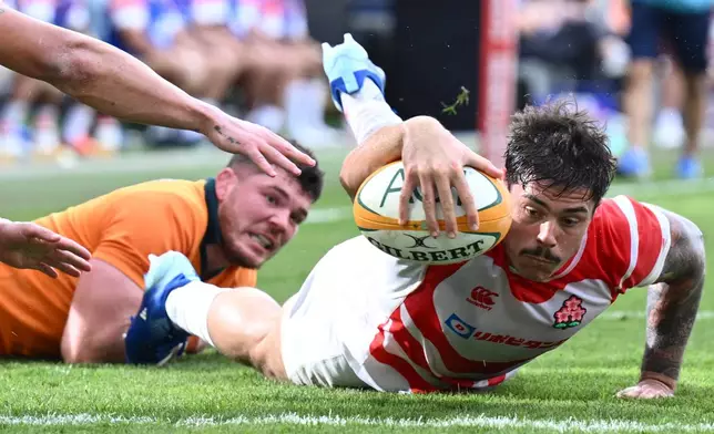 Dylan Riley, right, of Japan reaches out to score a try during a rugby international between Japan and Australia in Townsville, Australia, Saturday, Aug.15, 2026. (Matt Taylor/AAPImage via AP)