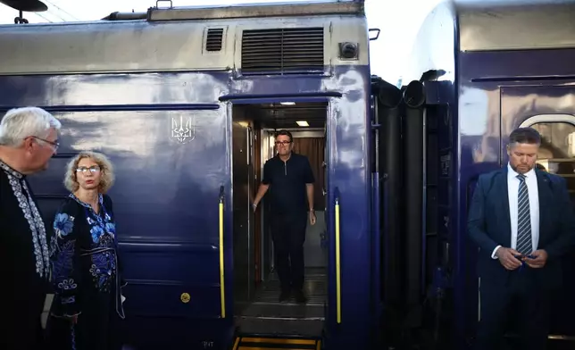 Britain's Prime Minister Andy Burnham, centre, walks out of a train upon his arrival , in Kyiv, Monday, Aug. 24, 2026. (Henry Nicholls/Pool Photo via AP)