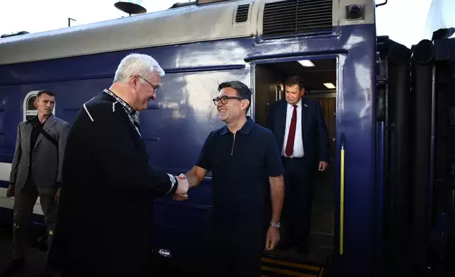 Ukraine's Foreign Affairs Minister Andrii Sybiha, left, greets Britain's prime minister Andy Burnham upon his arrival by train, in Kyiv, Monday, Aug. 24, 2026. (Henry Nicholls/Pool Photo via AP)