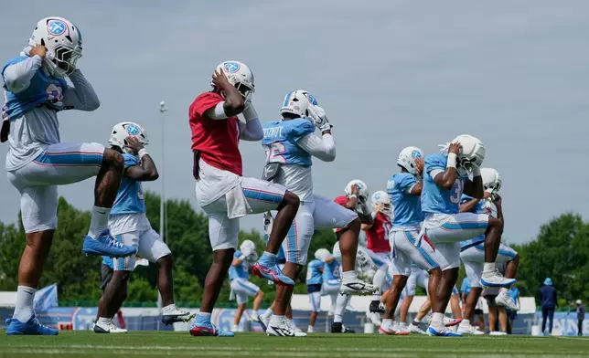Tennessee Titans quarterback Cam Ward, center, warms up with teammates during the NFL football team's training camp Tuesday, Aug. 4, 2026, in Nashville, Tenn. (AP Photo/George Walker IV)