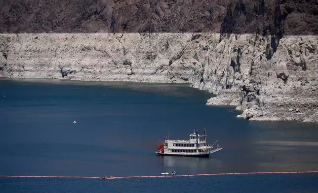 A paddle boat in Lake Mead near the Hoover Dam, far below the bathtub ring of light minerals indicating the lack of water, near Boulder City, Nev., on Friday, Aug. 7, 2026. (AP Photo/Ty ONeil)