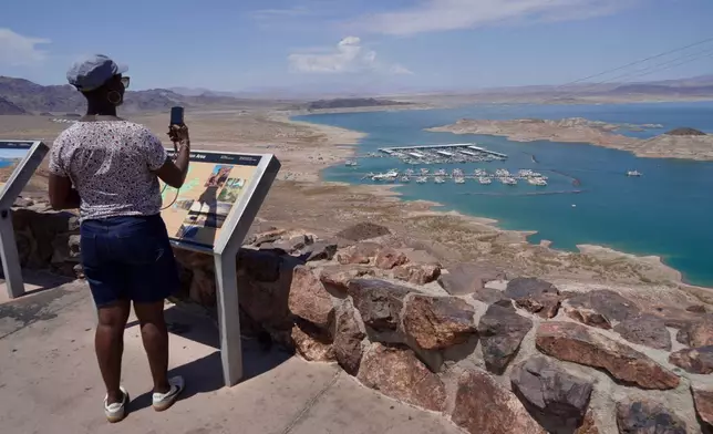A tourist takes a photo of Lake Mead near Boulder City, Nev., on Friday, Aug. 7, 2026. (AP Photo/Ty ONeil)