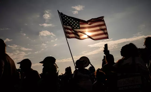 A demonstrator holds an American flag near the Lincoln Memorial before the March on Washington, Friday, Aug. 28, 2026, in Washington. (AP Photo/Julia Demaree Nikhinson)