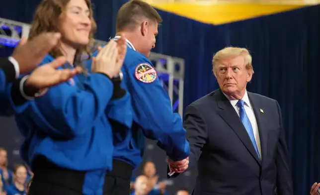 President Donald Trump, from right, shakes the hand of Artemis II crew member Jeremy Hansen after presenting him the Congressional Space Medal of Honor as fellow recipient Christina Koch applauds, Friday, Aug. 28, 2026, at Johnson Space Center in Houston. (AP Photo/Mark Schiefelbein)