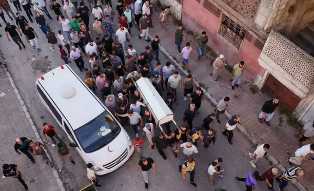 Mourners carry the coffin of Mohammad Ghamira, a former White Helmets volunteer who died shortly after his release from jail, for burial in the village of al-Haffa, in Latakia province, Syria, Monday, Aug. 17, 2026. (AP Photo)