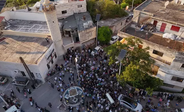 Mourners carry the coffin of Mohammad Ghamira, a former White Helmets volunteer who died shortly after his release from jail, for burial in the village of al-Haffa, in Latakia province, Syria, Monday, Aug. 17, 2026. (AP Photo)
