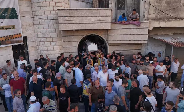 Mourners carry the coffin of Mohammad Ghamira, a former White Helmets volunteer who died shortly after his release from jail, for burial in the village of al-Haffa, in Latakia province, Syria, Monday, Aug. 17, 2026. (AP Photo)